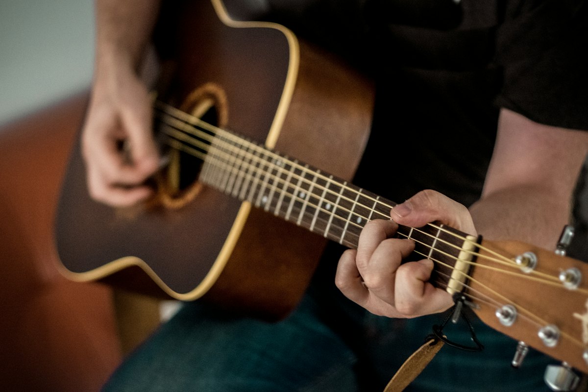 Close-up of hands fretting a chord and strumming an acoustic guitar