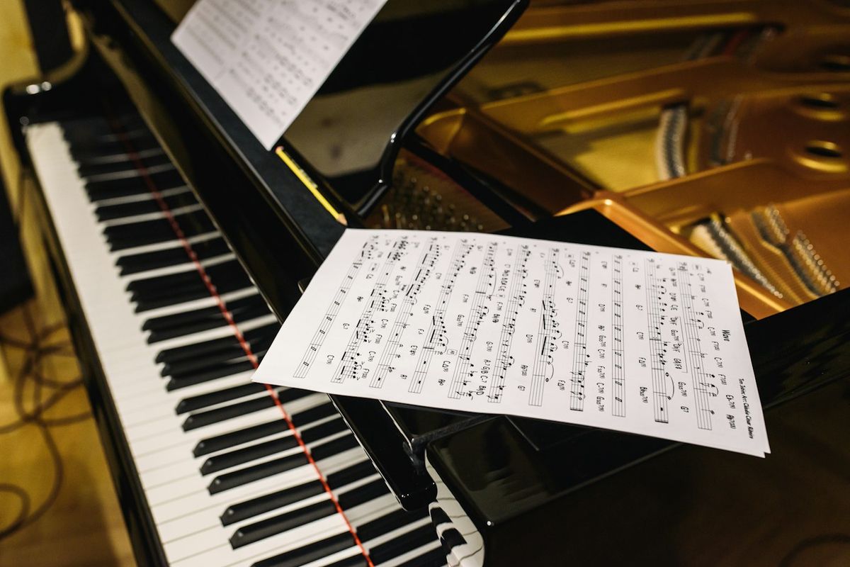 Sheet music resting on the keys of a grand piano