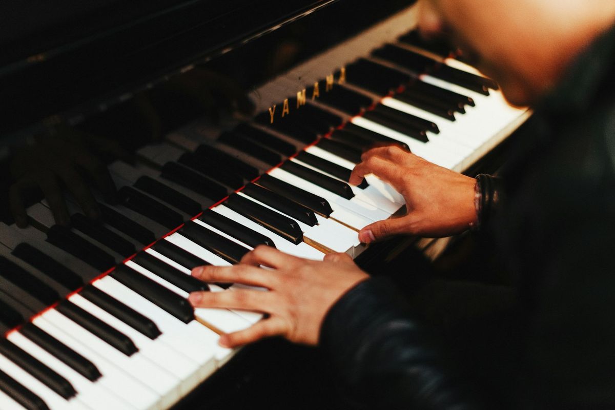 Person playing a piano, seen from above the keys